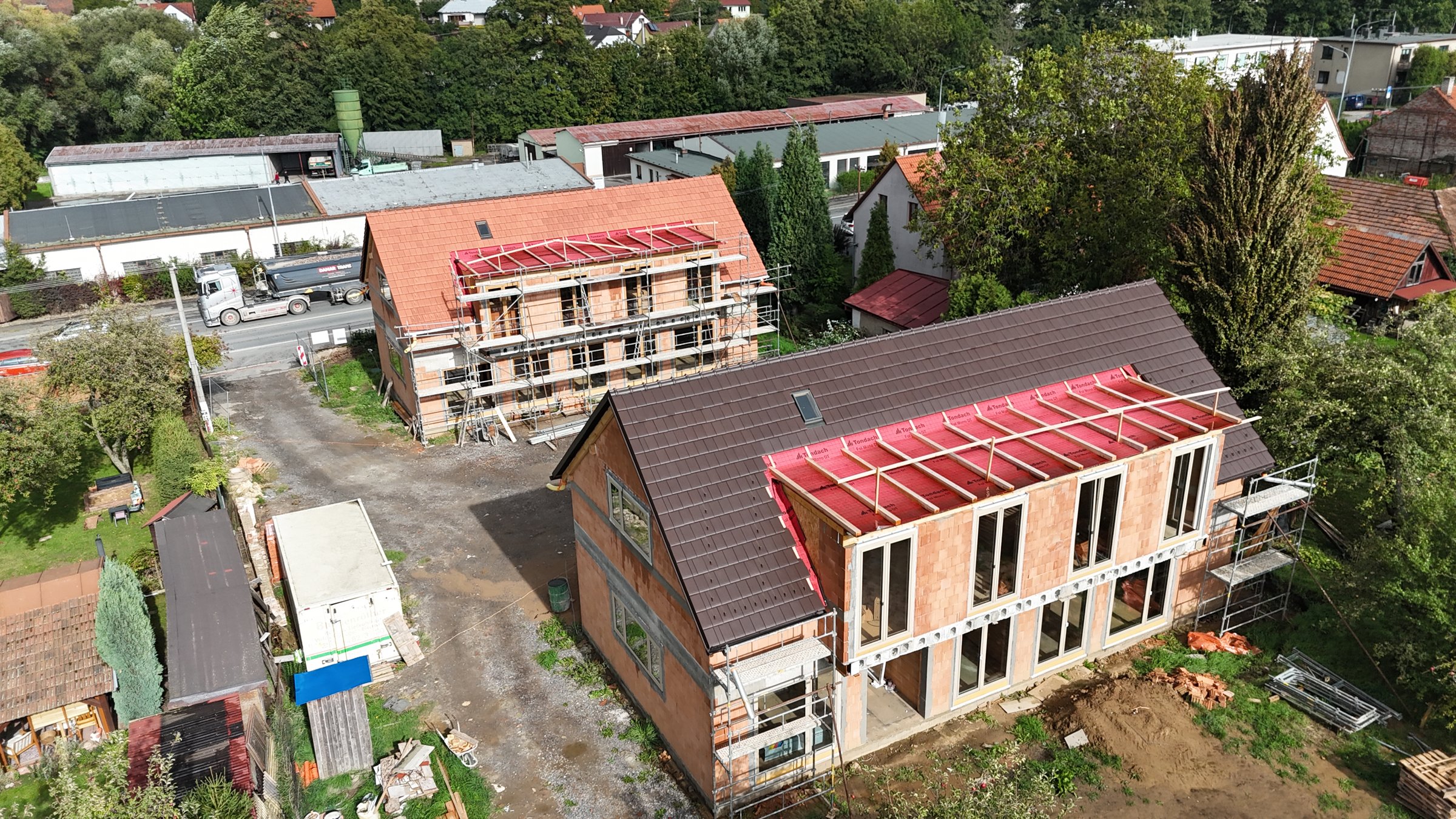 Stavba dvou domů z dronu, oba domy v obvodovém zdivu se střechou